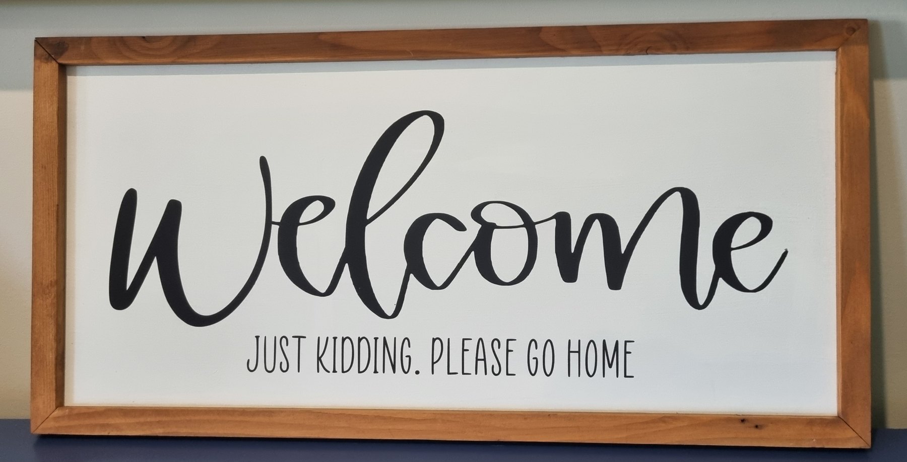 Framed timber welcome sign with playful custom wording